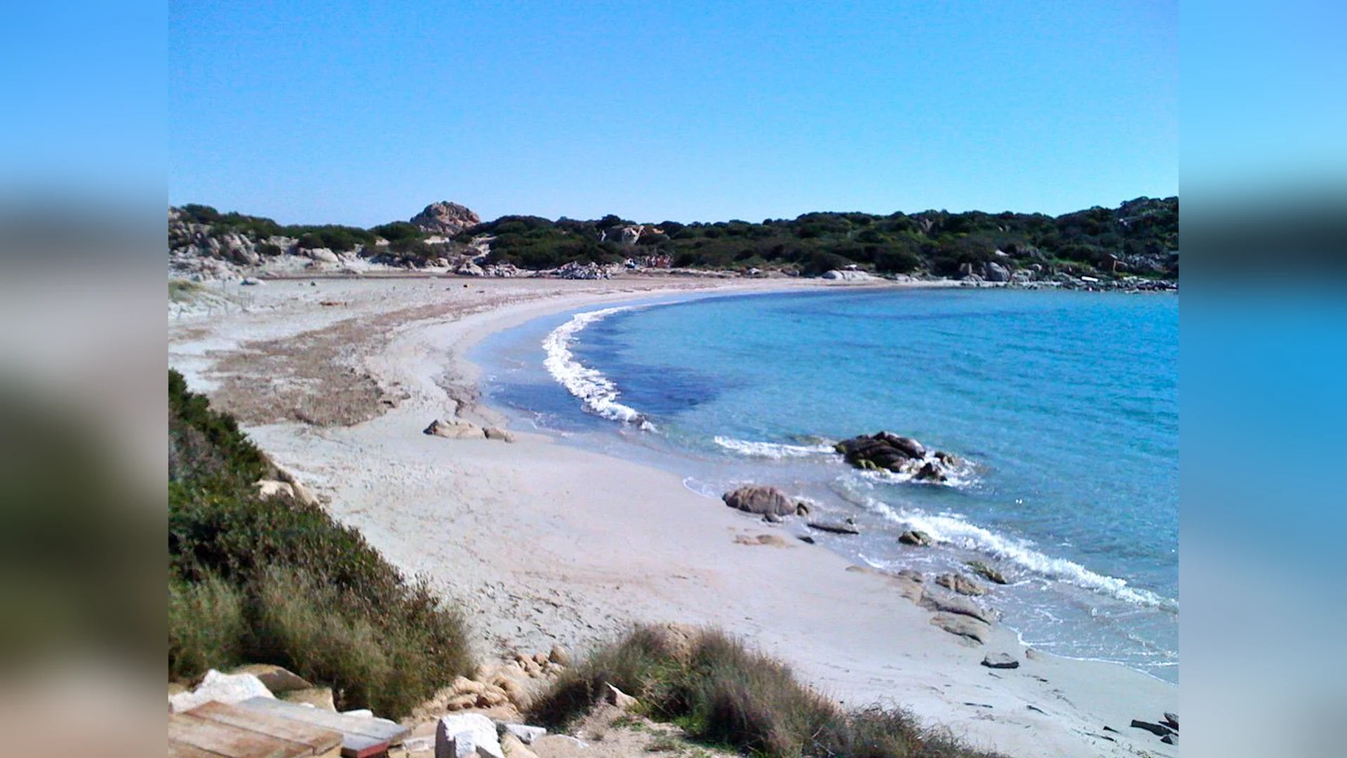 Una spiaggia con scogli e acqua limpida