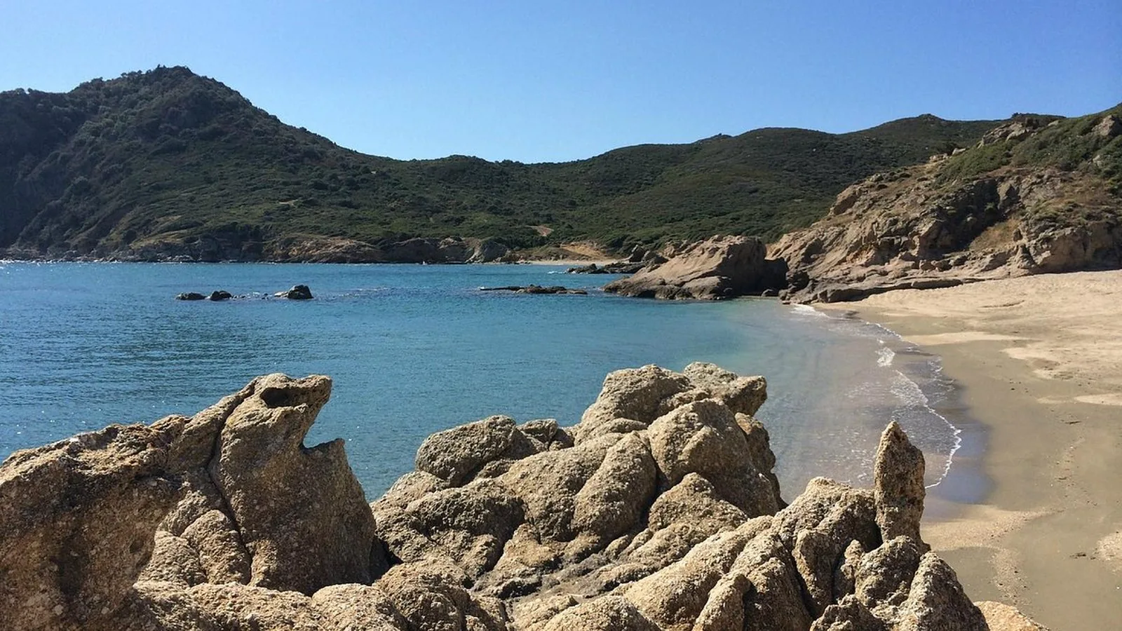 La spiaggia di Feraxi con le rocce e la macchia mediterranea
